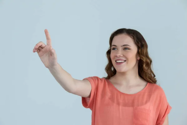 Vrouw voorwenden om een onzichtbare touchscreen — Stockfoto