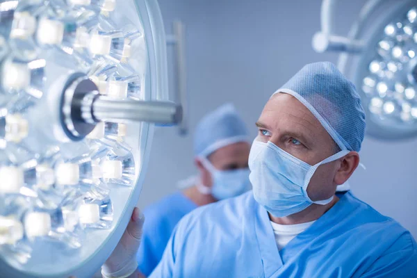 Male surgeon adjusting surgical light — Stock Photo, Image