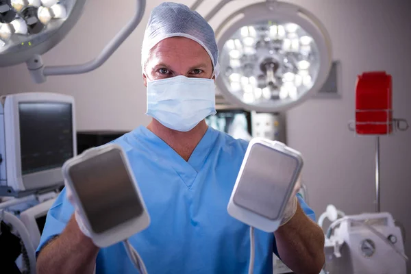 Male surgeon holding defibrillator — Stock Photo, Image