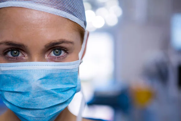 Kvinnliga kirurgen bär kirurgisk mask — Stockfoto