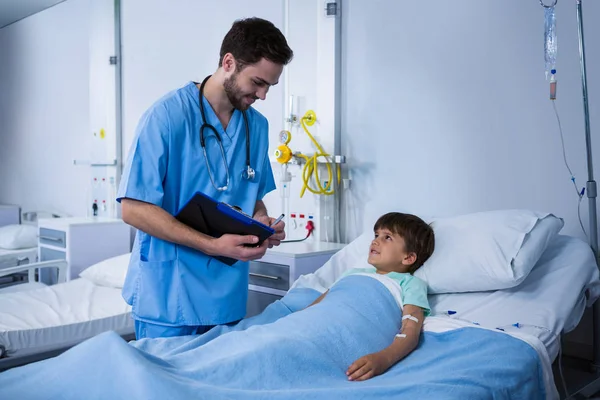 Медсестра-мужчина взаимодействует с пациентом во время посещения — стоковое фото