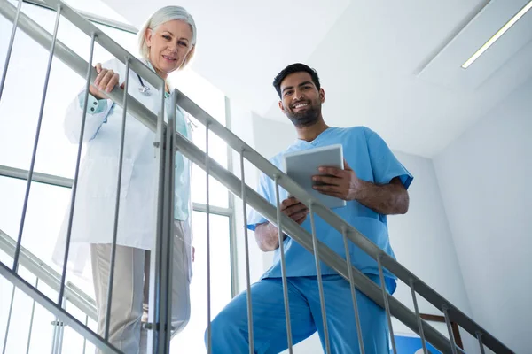 Doctors smiling while standing on staircase — Stock Photo, Image