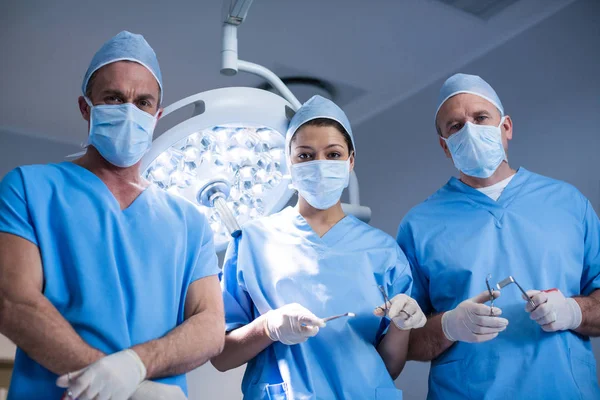 Χειρουργοί κρατώντας χειρουργικό εργαλείο — Φωτογραφία Αρχείου