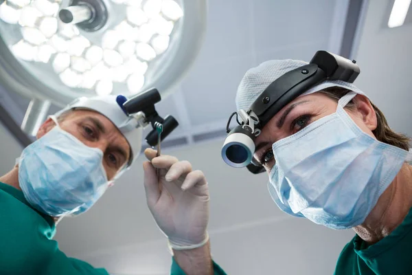 Cirurgiões segurando ferramenta cirúrgica — Fotografia de Stock