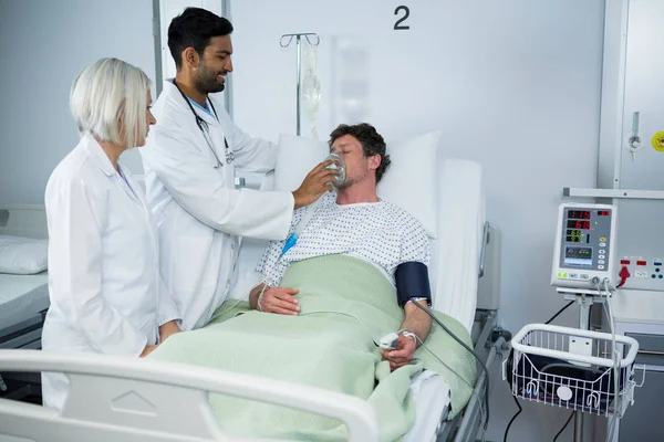 Doctor placing an oxygen mask on face of patient — Stock Photo, Image