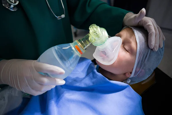 Chirurg setzt Sauerstoffmaske auf Mund des Patienten — Stockfoto