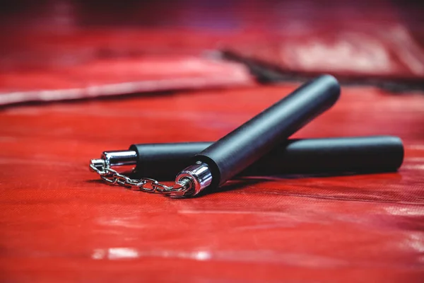 Nunchaku sobre fondo rojo — Foto de Stock