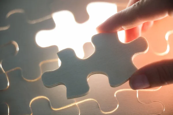 Woman placing missing piece in jigsaw puzzle — Stock Photo, Image