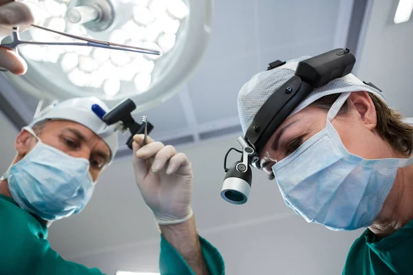 Surgeons holding surgical tool — Stock Photo, Image