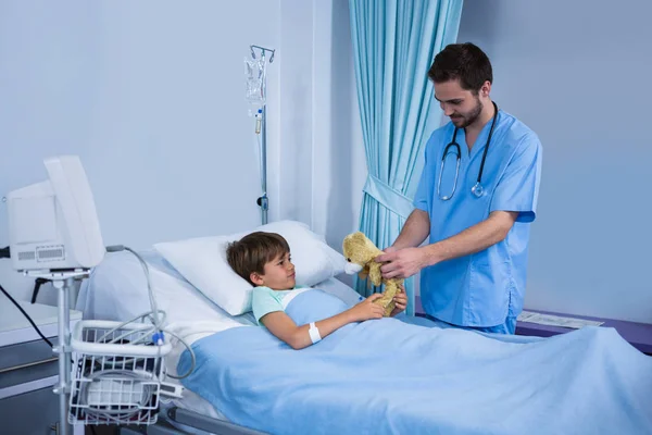 Krankenschwester gibt Teddybär während Besuch an Patientin — Stockfoto