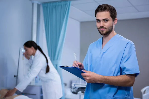 Médico escrevendo na área de transferência — Fotografia de Stock