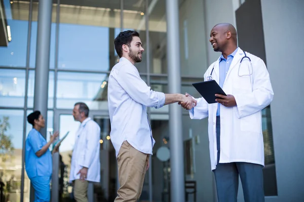 Doctor and patient shaking hands — Stock Photo, Image