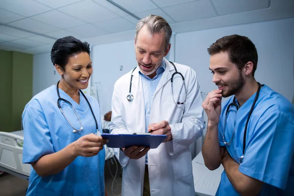 Médico e enfermeiro discutindo sobre prancheta — Fotografia de Stock