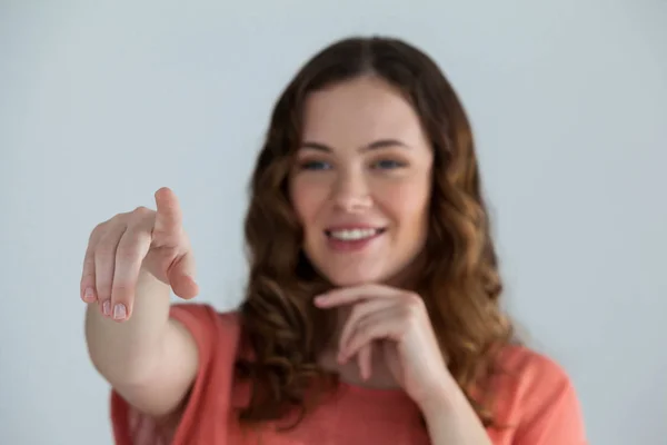 Mulher fingindo tocar em uma tela invisível — Fotografia de Stock