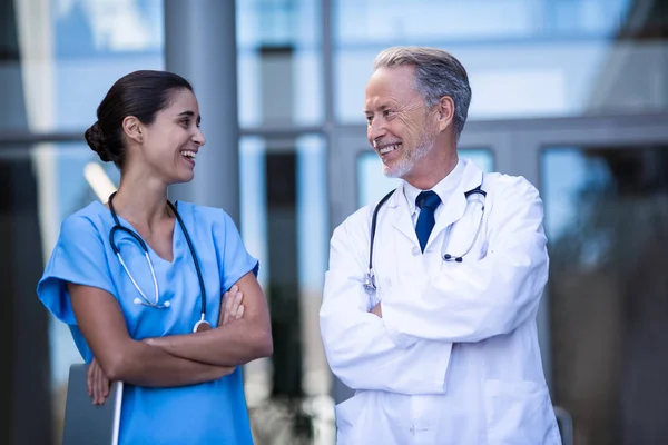 Lekarz i pielęgniarka, stojąc z rękami skrzyżowanymi — Zdjęcie stockowe