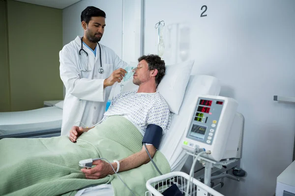 Médico colocando una máscara de oxígeno en la cara del paciente — Foto de Stock