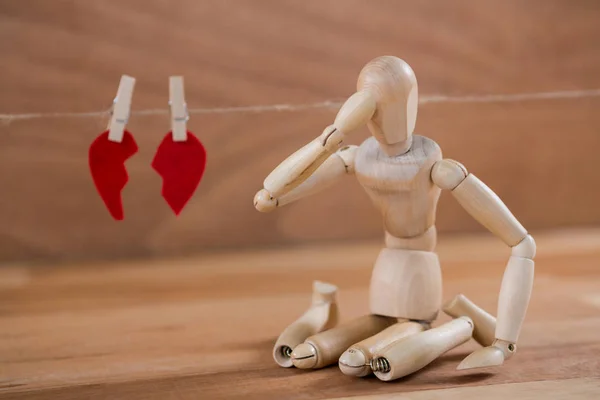 Figura sentada frente al corazón roto — Foto de Stock