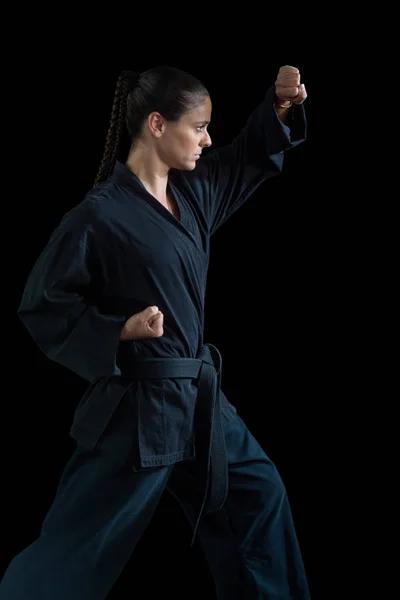 Giocatrice di karate femminile che esegue una posizione di karate — Foto Stock