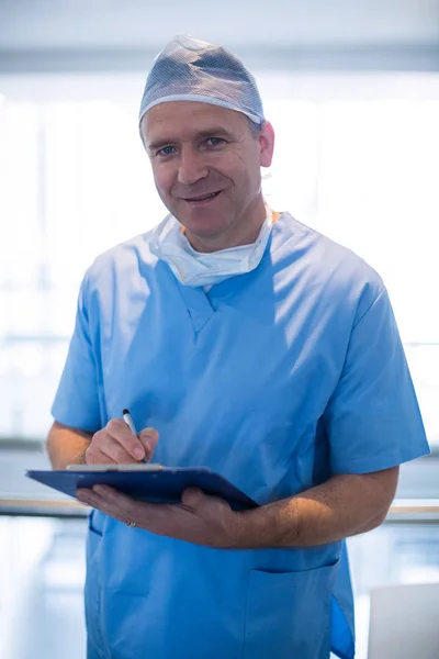 Αρσενικό χειρουργός γράφοντας σε ένα πρόχειρο — Φωτογραφία Αρχείου