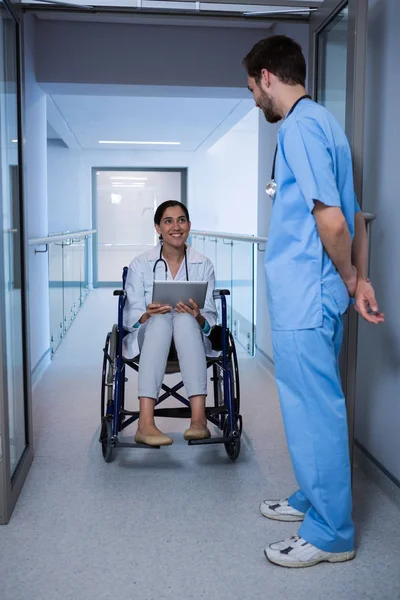 Doctor en silla de ruedas interactuando con enfermera —  Fotos de Stock