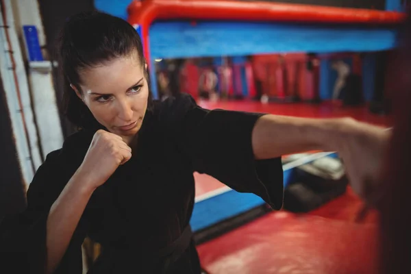 Karate-Spielerin übt Boxen mit Boxsack — Stockfoto