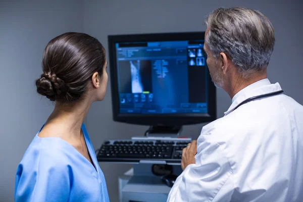 Médico y enfermera examinando rayos X en la computadora — Foto de Stock