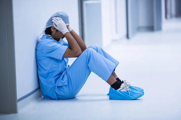 바닥에 앉아 슬픈 외과 의사 — 스톡 사진