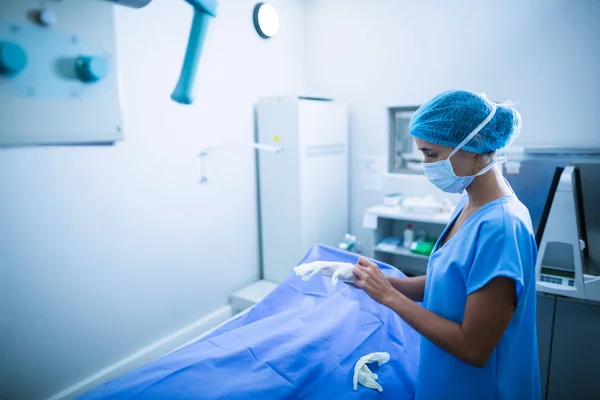 Verpleegkundige dragen chirurgische handschoenen in x-ray kamer — Stockfoto