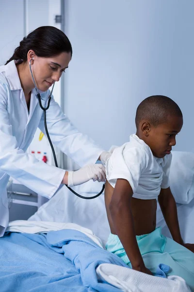 Médico examinando paciente con estetoscopio — Foto de Stock