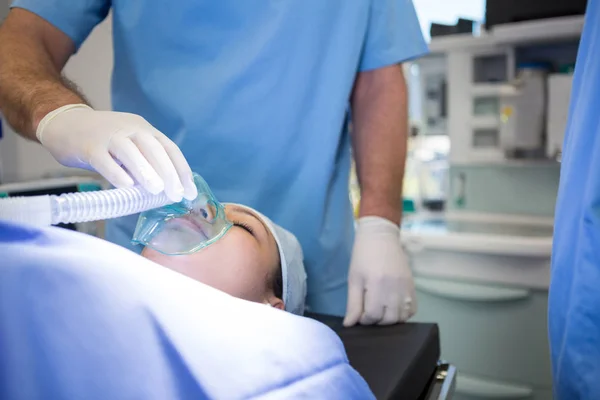 Medico che posiziona una maschera di ossigeno sul viso del paziente — Foto Stock