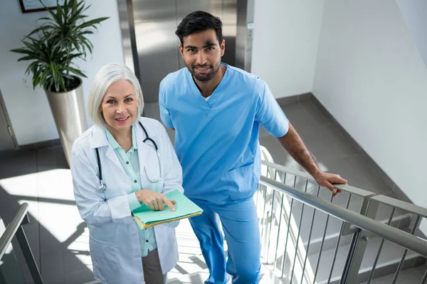 Doctors discussing over report on stairs — Stock Photo, Image