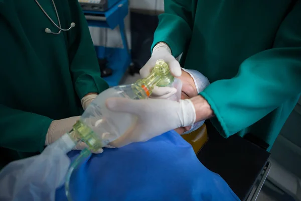 Surgeons placing oxygen mask — Stock Photo, Image