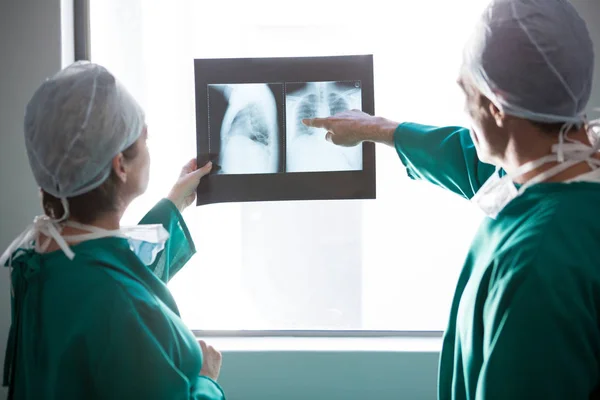 Cirujanos examinando un informe de rayos X — Foto de Stock