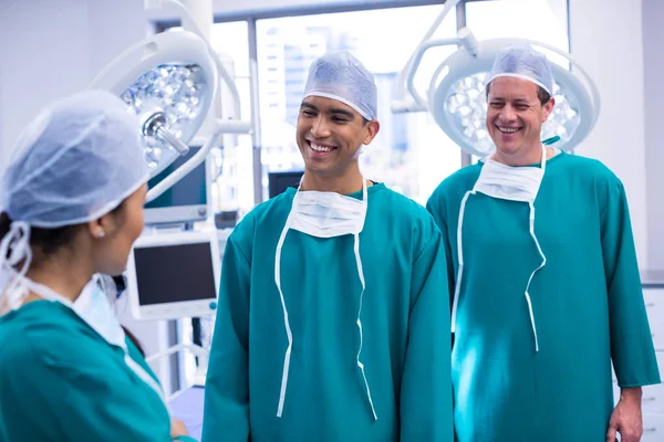 Χαμογελώντας χειρουργοί που αλληλεπιδρούν μεταξύ τους — Φωτογραφία Αρχείου