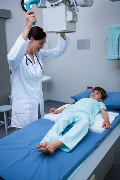 Médica mulher ajustando a máquina de raios-x no paciente — Fotografia de Stock