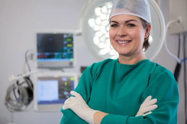 Chirurgo donna in piedi in sala operatoria — Foto Stock