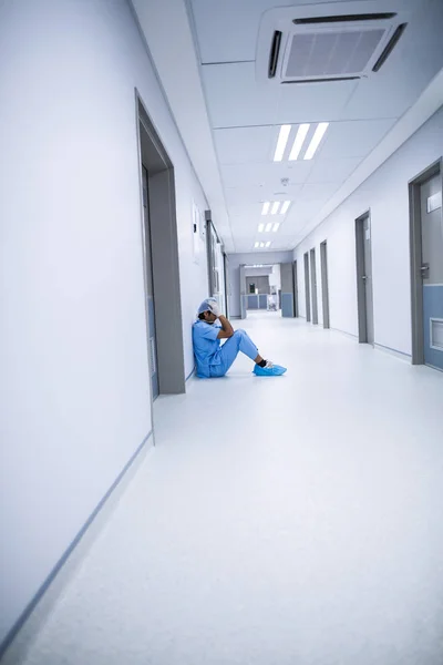 Trauriger Chirurg sitzt auf dem Fußboden — Stockfoto