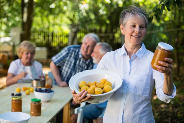 Senior vrouw met fles jam — Stockfoto