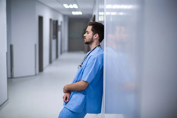 Verkrampte verpleger, leunend op de muur — Stockfoto