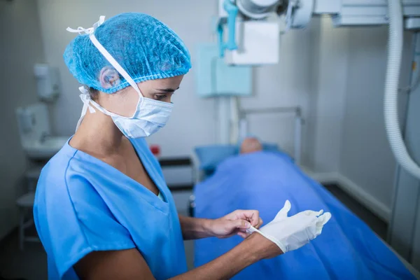 Infirmière portant des gants chirurgicaux dans une salle de radiographie — Photo