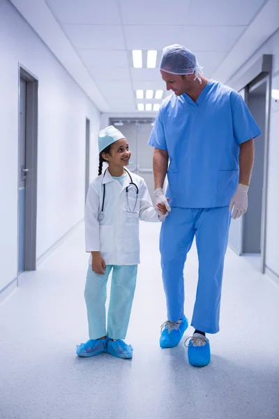 Médico e menina interagindo enquanto caminha — Fotografia de Stock