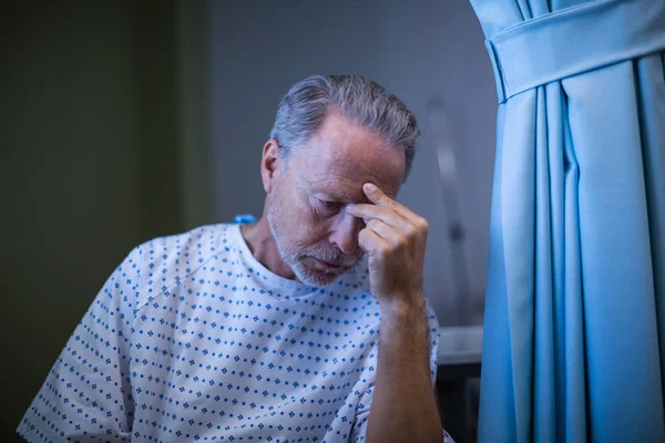 Triest patiënt zit op stoel met de hand op het hoofd — Stockfoto