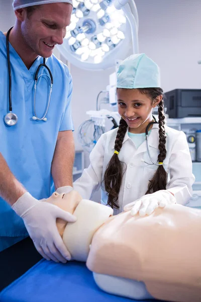 Läkare och flicka att undersöka en dummy — Stockfoto