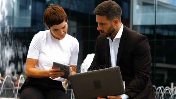 Empresarios discutiendo en tableta digital y portátil — Vídeos de Stock