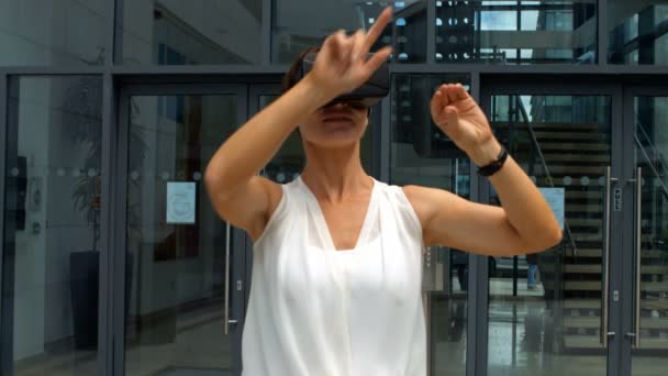 Женщина с помощью виртуальной гарнитуры реальности — стоковое видео