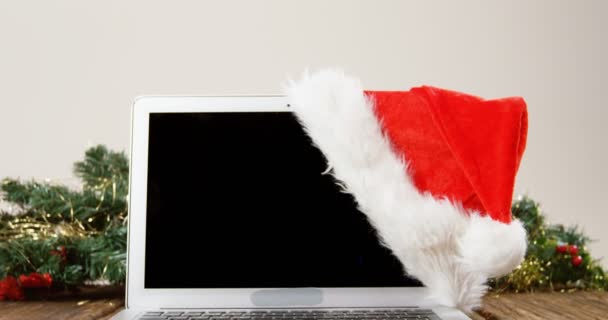 Laptop with santa hat on a plank — Stock Video