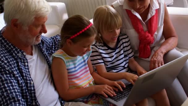 Petits-enfants utilisant un ordinateur portable avec leurs grands-parents — Video