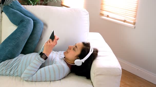 Mulher ouvindo música em fones de ouvido — Vídeo de Stock