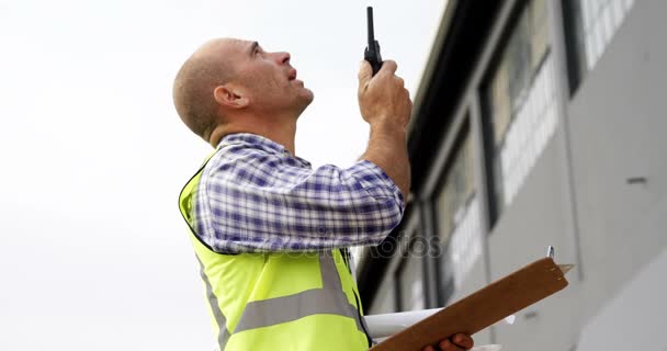Construction worker talking on walkie-talkie — Stock Video