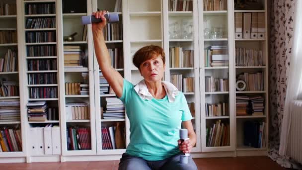 Старшая женщина упражняется с гантелями — стоковое видео
